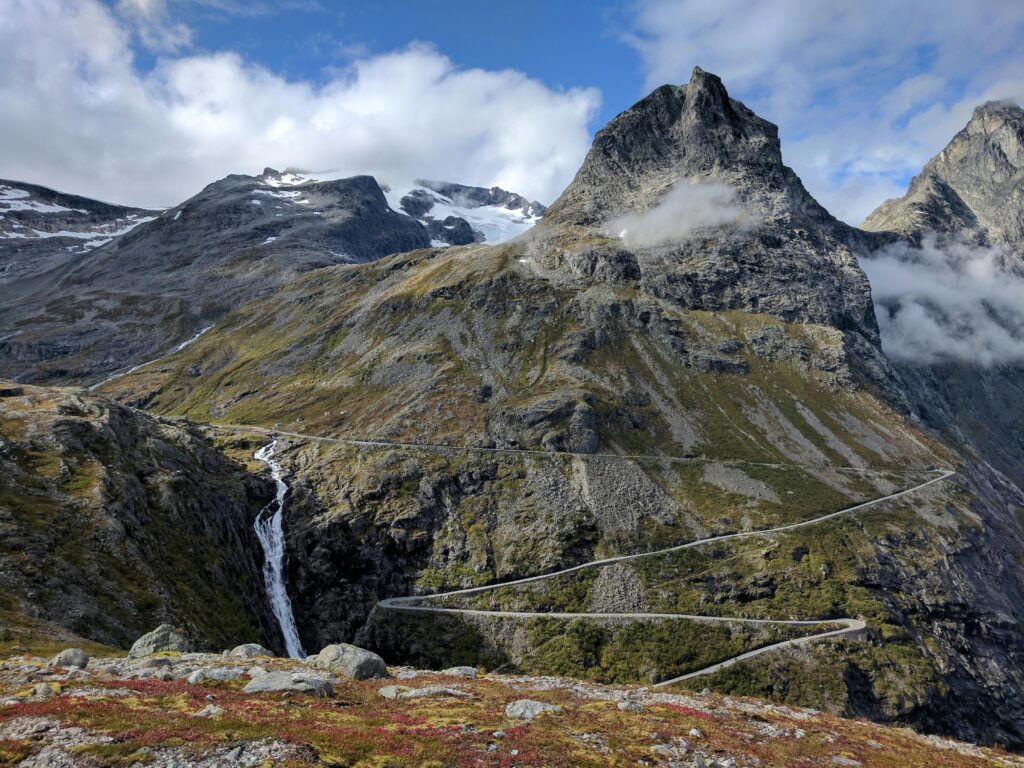 A breathtaking view of Trollstigen mountain pass in Norway with winding roads and lush scenery.